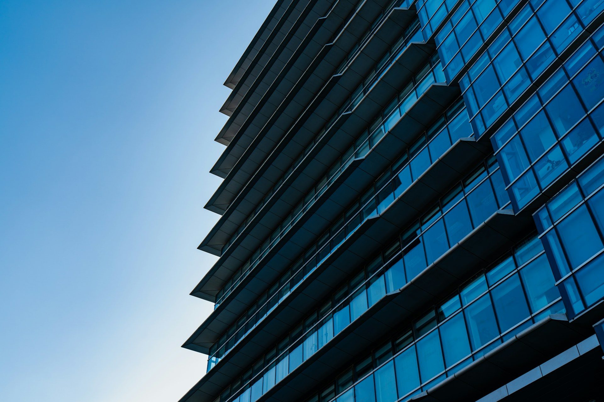 Modern skyscraper with blue glass windows against sky
